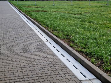 Leke borular yağmur suyu ve yağ maddelerini kurutur, asfaltlı yüzeylerden damlar. Kaldırımdaki beton ürünler birbirine kenetlenmiş fayanslar. Kanalizasyon boruları yüzeyin altında gizli