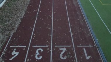 Birkaç şeritli koşu pisti olan bir spor stadyumu. Oval Ofis 'te netbol ve hentbol için kalkan engelleri olan küçük bir futbol sahası var. Sentetik bölge. Yukarıdan görünüm, tüm hava yolları