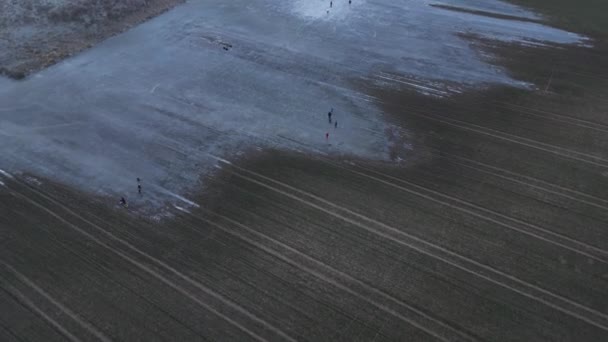 除了对农民的伤害之外 洪水泛滥的田野是个很好的溜冰场 打曲棍球或滑过一个大水坑都有来自上方的镜头记录 村里有趣的孩子 — 图库视频影像