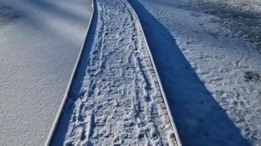 Tahtadan yapılmış yüzen bir yürüyüş yolu. Göl suyunun üzerinde, dibe doğru kazık çakılmış dar patikalar. Korkuluğun yok ki. Doğal koruma altındaki bir alanda suyun üzerinden geçen tasarım.