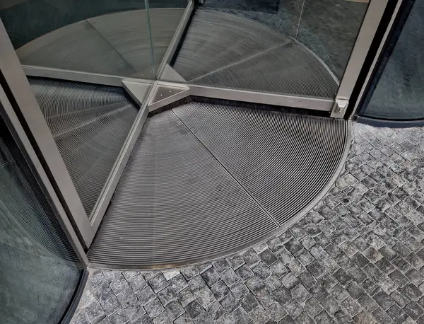 entrance to the building through a revolving door with 4 wings. has a revolving door, which spins constantly as people come and go. heating, energy savings