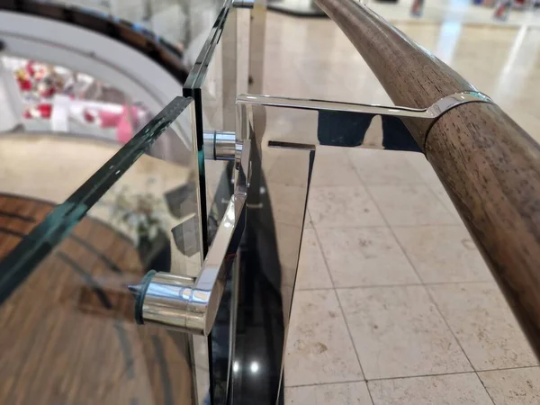 handle on the glass railing is stylishly simple, the wooden bars on the holders are made of polished stainless steel. mounting on the glass by drilling and screws. public buildings