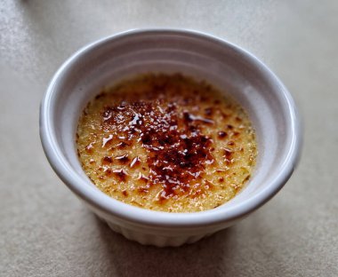 En sevdiğim İtalyan tatlısı. Pudingimizin daha hafif bir versiyonu. Panna cotta kaynamış krema demek. Porselen kâse ve karamelize şeker. Flamb tabancası, Üçlemeci kreması, yanmış.