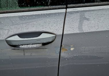 Arabanın çizilmiş tarafı. Boyanın üzerindeki küçük çizikler çürüyerek, 2000 'lik zımpara kağıdıyla zımparalanarak, ardından da renk doldurucu ve şeffaf boya sıkarak onarılabilir. Araba boyacısı, mağaza.