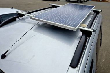 Gezginlerin çatıdaki küçük karavanın çatısında güneş paneli var. Çok basit, bataryaları şarj etmek için güneşi kullanabilir ve ev yapımı arabanın içini aydınlatabilir.