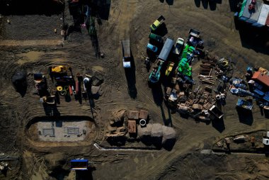 Bir sürü makineli inşaat alanı. Güvenlik için tuğla ve izolasyon tahtalarını önceden satın alan evler ve okulların inşası. İnşaat çalışmalarının fiyatlarındaki dalgalanmalar