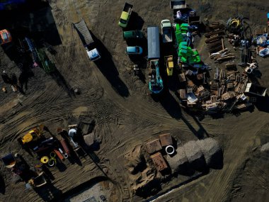 Bir sürü makineli inşaat alanı. Güvenlik için tuğla ve izolasyon tahtalarını önceden satın alan evler ve okulların inşası. İnşaat çalışmalarının fiyatlarındaki dalgalanmalar