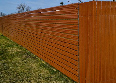 Beton bloklardan oluşan çitin metal dolguları. Metal bir alüminyum çit bahçede mahremiyet sağlayacak. Yatay kirişler iyi korunuyor. beton bloklama koruması