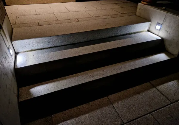 lighting of stairs and steps on the concrete wall on the side of the stairs. recessed reflectors shine underfoot and create a clear and safe scene for movement at night. hotel exterior of the resort