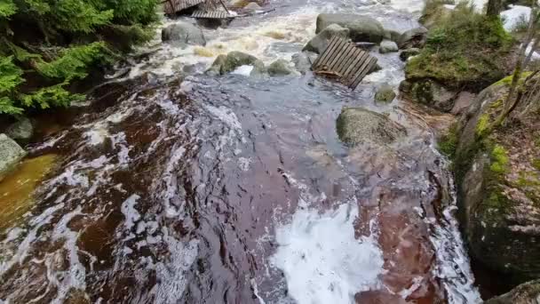 山の川に水が散らばっている 損傷した木製のマストは 洪水で洗い流され 岩に押しつぶされました 新しい金属耐久の橋はの波に耐えます — ストック動画