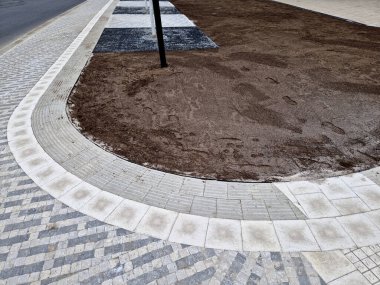 Toprağı hazırlamak, çim ekmek için toprağı tartmak. Yeni dikilmiş ağaçlar üç kazıkla güvenceye alınır..