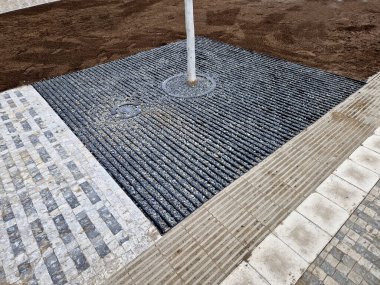 Toprağı hazırlamak, çim ekmek için toprağı tartmak. Yeni dikilmiş ağaçlar üç kazıkla güvenceye alınır..