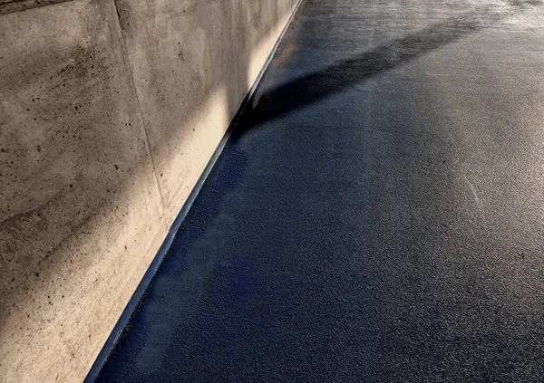 Gri lateks boyalı yeni boyanmış garaj zemini. Yüzey parlak ve bakımı kolay. Yağ ve kimyasallara dayanıklı. Islak ve parlak görünüyor.