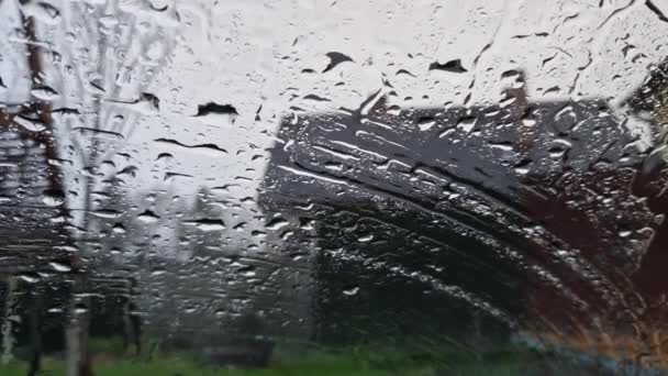 在车里等雨对大多数人来说都很烦人 你忘了你的雨伞 宁愿看那些从挡风玻璃上滑落下来的雨滴 — 图库视频影像