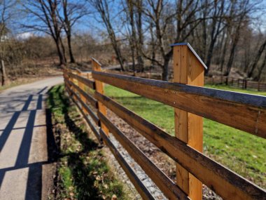 Kırsal çiftlik tarzı ahşap çitler. Direğin direkleri yerden çürümesin diye metal çivilerin üzerinde. Tepesi eğimli ve su girişine karşı metal bir çatı ile kaplı.