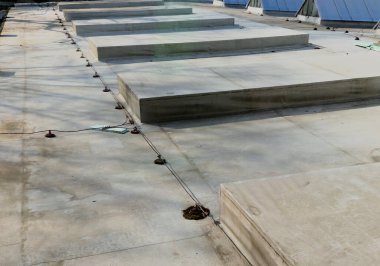 A lightning conductor is used to protect buildings from lightning that can damage a house or its electrical equipment is routed to the highest points of a green garden roof.