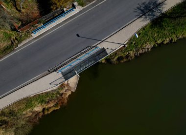Su geçidi üzerindeki göletin köprü kolunda şeffaf ağdan yapılmış yayalar var. Gölün etrafındaki sahil şeridi.