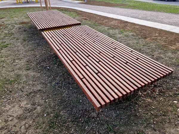 Parka bakan yükseltilmiş terasın kenarında ahşap panelli ve dikdörtgen banklı uzun bir saksı var. Şehrin cadde ve meydanındaki gezinti alanlarından biri.