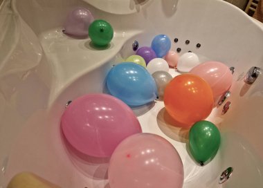 Çocuklar küvette şişme balonlarla oynuyorlardı. Girdap jetleri olan lüks bir köşe banyosu. Bu boş küvete atla.