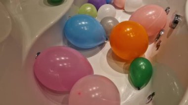 Çocuklar küvette şişme balonlarla oynuyorlardı. Girdap jetleri olan lüks bir köşe banyosu. Bu boş küvete atla.