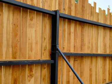 Altında çeltik olan bir arsaya. Çitin tepesi bitmemiş bir çit gibi tahtalardan tırtıklı. Özensiz bakış kasıtlıdır.