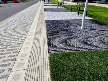 Toprağı hazırlamak, çim ekmek için toprağı tartmak. Yeni dikilmiş ağaçlar üç kazıkla güvenceye alınır. Çim, çimen, yeşil