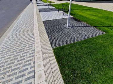 Toprağı hazırlamak, çim ekmek için toprağı tartmak. Yeni dikilmiş ağaçlar üç kazıkla güvenceye alınır. Çim, çimen, yeşil