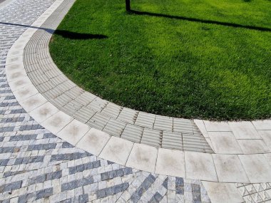 Toprağı hazırlamak, çim ekmek için toprağı tartmak. Yeni dikilmiş ağaçlar üç kazıkla güvenceye alınır. Çim, çimen, yeşil