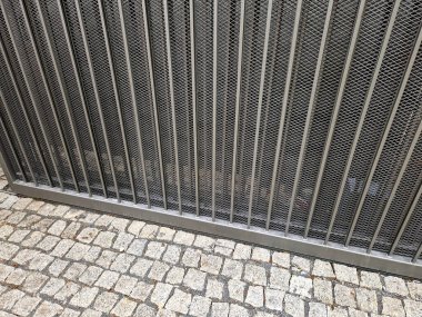 entrance to the yard to the parking lot through a low sliding gate. the gate moves sideways along the rail. there is an orange flashing beacon on the post. the remote control turns on sliding gate