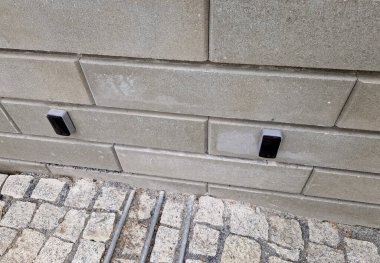 Otoparkın girişi alçak sürgülü kapıdan. Kapı demiryolu boyunca yana doğru hareket ediyor. Direkte turuncu ışıklı bir fener var. Uzaktan kumanda sürgülü kapıyı açar