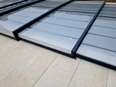 Katlanan havuz çatısı. Alüminyum ve pleksiglass kapağı raylarda çalışır. Havuzu çevreden kirden korur ve ısı sızıntısını önler ve güneşten ısı toplamaya yardımcı olur.
