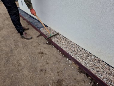 Evin etrafında çakıl ve çakıl taşlarından oluşan bir oluk oluşturmak her zaman gereklidir. Suyu emmeye ve evin duvarlarını havalandırmaya yarıyor. Kaldırım çelik levhaların montajı. zar folyosu