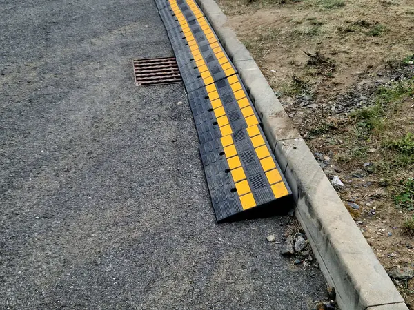 Stock image safety crossing wedge made of plastic with reflective elements. anti-skid plastic approach over the curb to the construction site