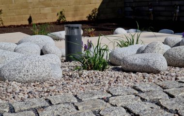 Süslü çiçek tarhı. Gri granitten yapılmış taşlar, şehir bahçesinde saman taşları, çayır, süs otları, havuz kenarında teras, çakıl taşı, mor, beyaz...