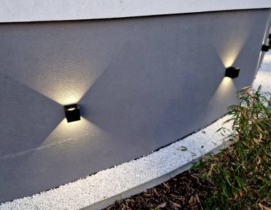 Leke duvar ışığı evin ön cephesinin duvarını gece koni şeklinde aydınlatıyor. Akşam konumu ve seyrüsefer lambası Gabion duvarında iki yönde parlar.