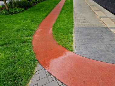 Kırmızı kauçuk malzemeden yapılmış bir rota. Yıl boyunca kaldırıma paralel ofis bölgesinde eğitim için yumuşak devre.