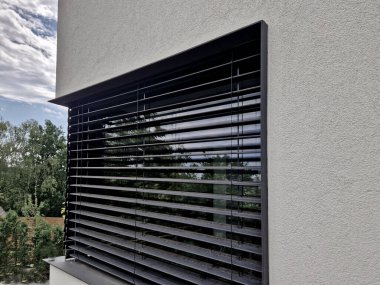 Evlerdeki ve apartmanlardaki pencerelerin dış gölgesi. Ön pencere perdeleriyle pencerenin önündeki güneş ışınını durdurabilirsin. İçerideki ışık miktarını düzenle. Klima mahremiyeti korur