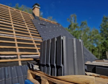 construction site with several roofs in progress. Roofs with vapor-permeable foil. roof tiles are placed on the roof. concrete chimney passes through. approval quality control. view from above clipart