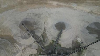 Kumu çakıl ve çakıl taşlarından ayırmak için ayrılık çizgisi. Taşıyıcı inşaat alanına veya beton fabrikasına taşınmak için büyük kümeler döker