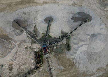 Kumu çakıl ve çakıl taşlarından ayırmak için ayrılık çizgisi. Taşıyıcı inşaat alanına veya beton fabrikasına taşınmak için büyük kümeler döker