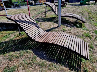Dalgalı bir çizgi şeklinde dizayn tezgahı. Metal galvanize çerçeve üzerinde ahşap paneller. Şehir parkında sıradışı bir şekilde oturan ve yalan söyleyen gençler için sıra dışıdır.
