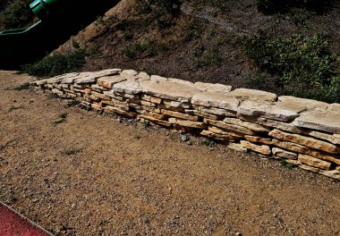  dry wall serves as a terrace terrace for the garden, where it holds a mass of soil. the wall is slightly curved, which helps it to stabilize better. planting perennials and rock gardens clipart