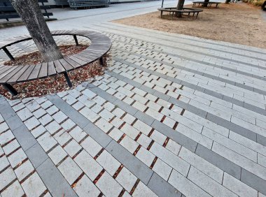  Şehirdeki gezinti güvertesine giden yol ağacın köklerinin altında asfaltlıdır. Eklemleri olan, yağmur yağdığında yüzey altında nefes alabilen ve ıslatabilen, geçirgen bir asfalt vardır.