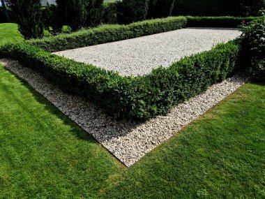 Boxwood çitlerinden yapılmış tarihi bir bahçede kesilmiş çiçek tarhı kareleri. Kalenin avlusu kaldırım taşı patika yolu boyunca donmuş buz sıraları, kar yeşil çimenler sarmaşık, sarmaşık, sarmaşık, sarmaşık, üst