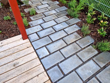 Bahçedeki düz taşlar, ağaç kabuğu parçacıkları ile samanlanmış bir yatak içeren bir patika oluşturur. İki sıra halinde basamaklar ziyaretçileri parka götürüyor.