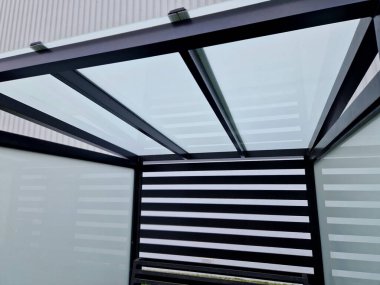 strut, suspended glass roof above the building entrance. bus station, railway station. cable wind braces. aluminum construction with windows above pergola  galvanized steel frame