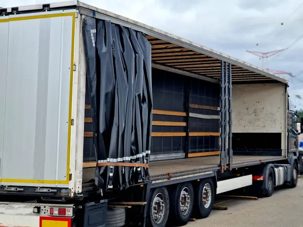 stock image customs control of a van or truck. the car's tarpaulins are raised and suspicious cargo boxes are visible on the pallet. Search for refugees in the body of the truck.