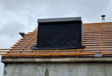 bay windows newly inserted into the roof during the renovation. two projections covered with vapor barrier film towards the street. clipart