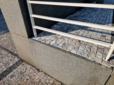 Dört beton vidayla yere sabitlenmiş çit direkleriyle köprü korkulukları. Parmaklıklar köprünün kenarından betona sabitlendi..