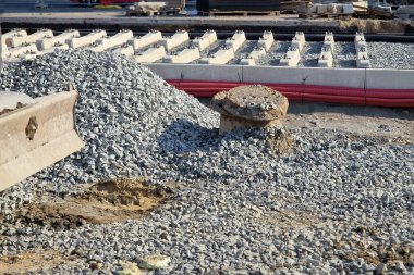 İki tramvay rayında çataldaki seviyelendirme cihazlarını kullanarak yeni ve kesin raylar döşemek. Üstlerine beton örtüler konmuş çakıl taşları... kauçuktan yapılmış kauçuk anti-titreşim tabanı